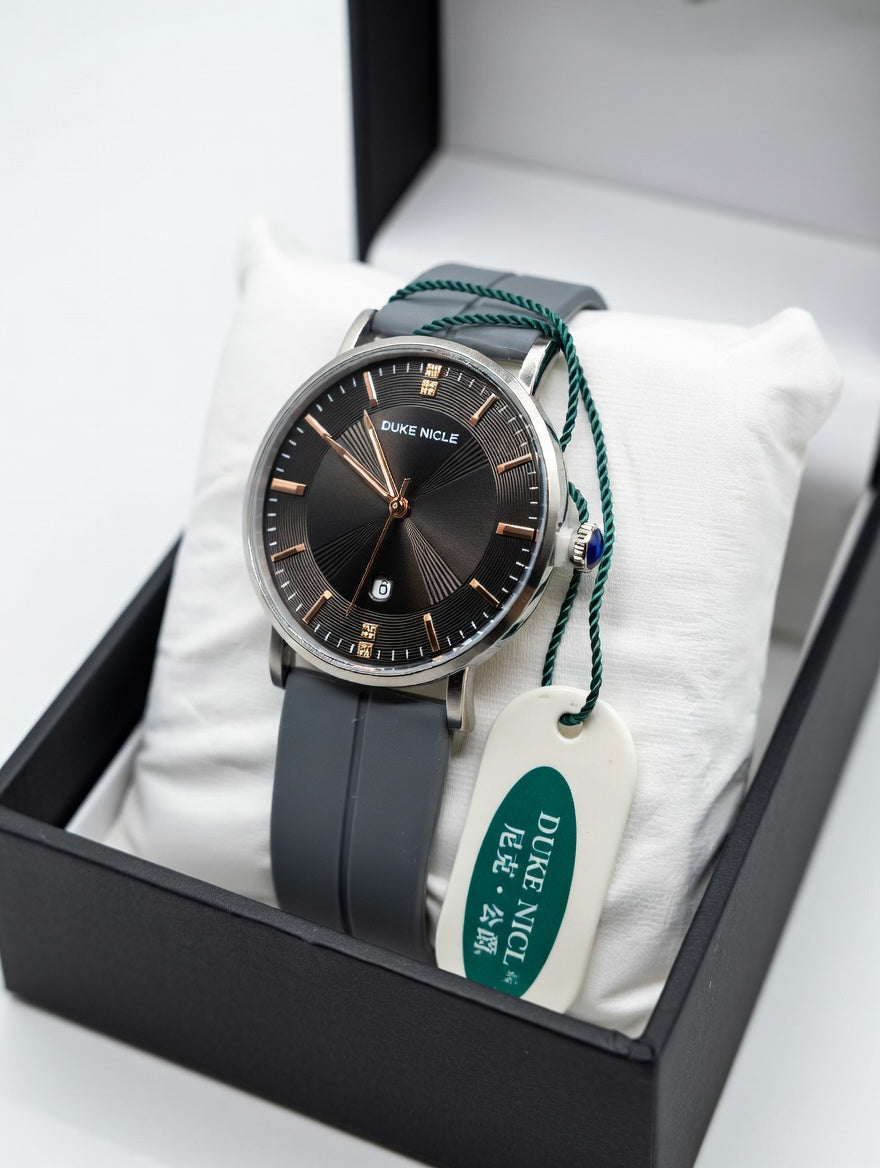 Duke Nicle men's wristwatch presented in its elegant black gift box with white pillow, gray silicone strap, and green tag on a clean white background