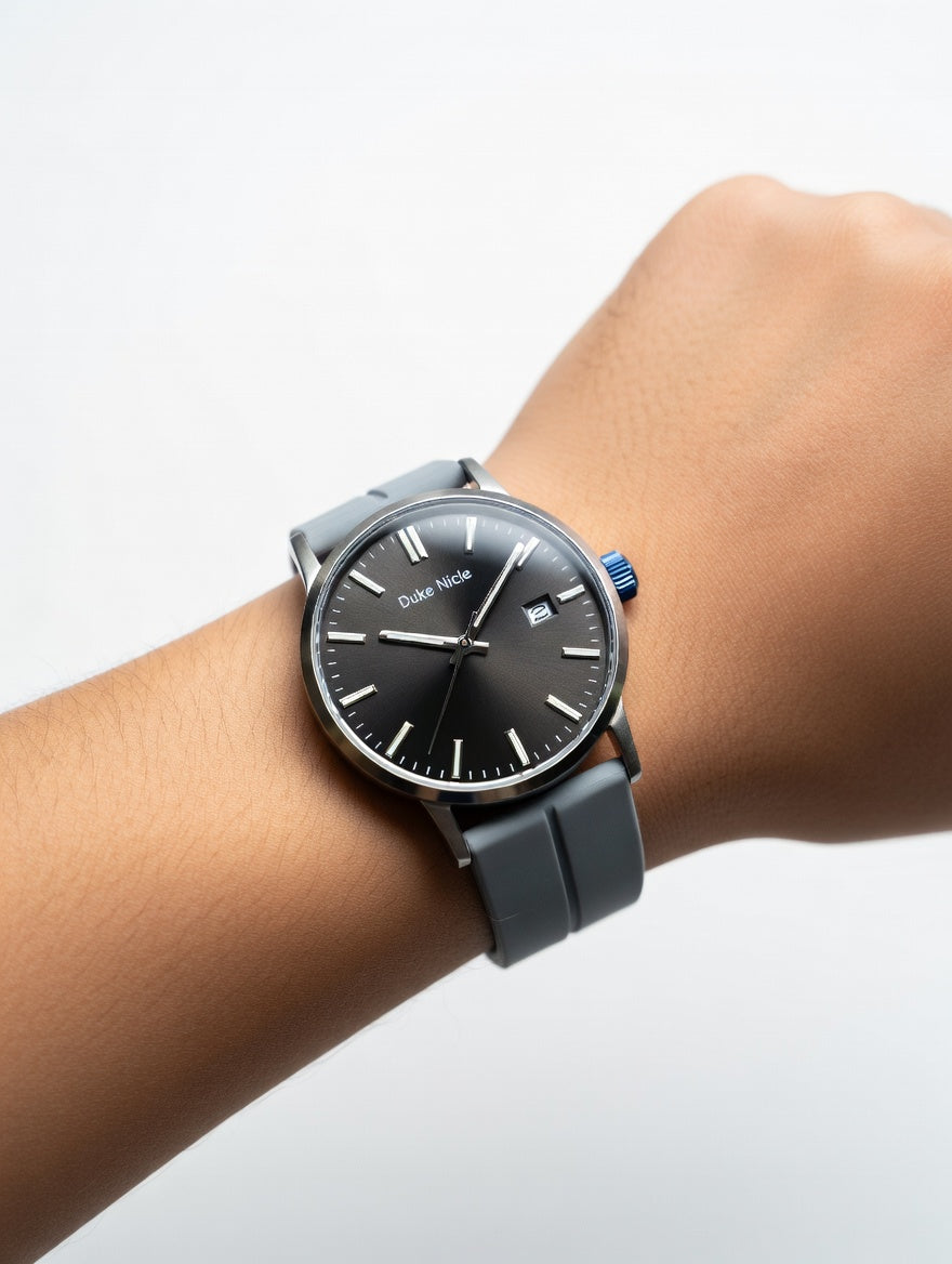 Duke Nicle men's wristwatch worn on wrist showing black dial, date window, and comfortable gray silicone strap on a clean light background