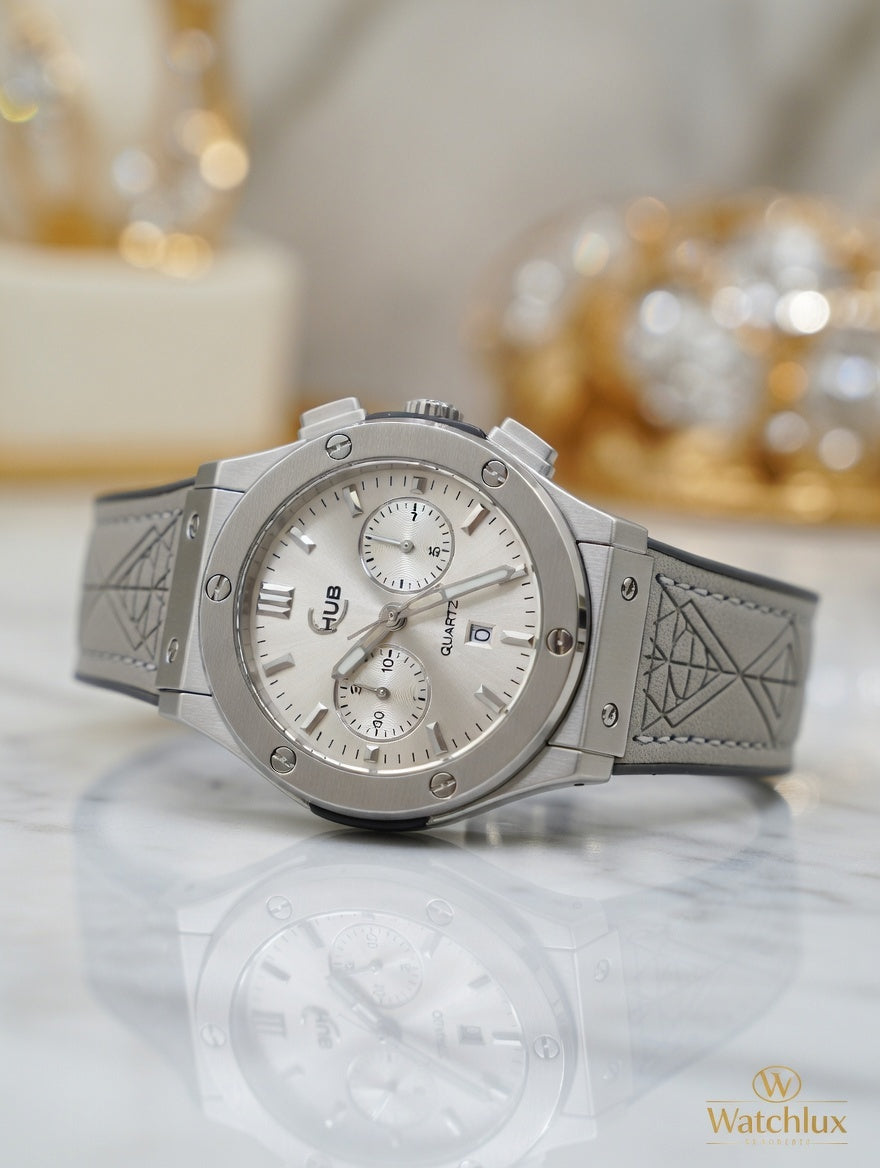 Luxury mens silver chronograph watch with white dial, subdials and silver leather strap, displayed on marble blurred background - Watchlux